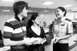 女民警遞上《來京外國人生產(chǎn)服務(wù)手冊(cè)》